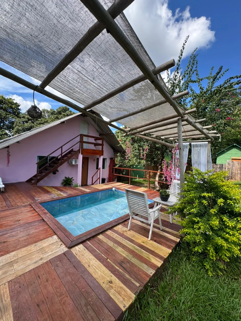 Cama de casal com lençóis brancos e vista para a natureza